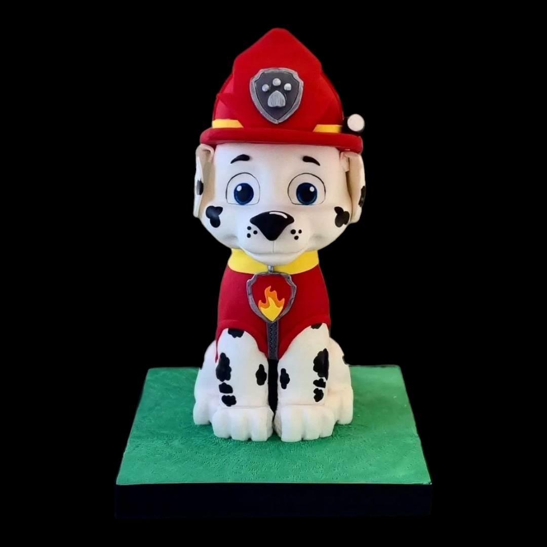 Marshall from Paw Patrol sculpted cake, featuring detailed fondant work with his red firefighter outfit, helmet, and signature Dalmatian spots, displayed on a green base with a black background